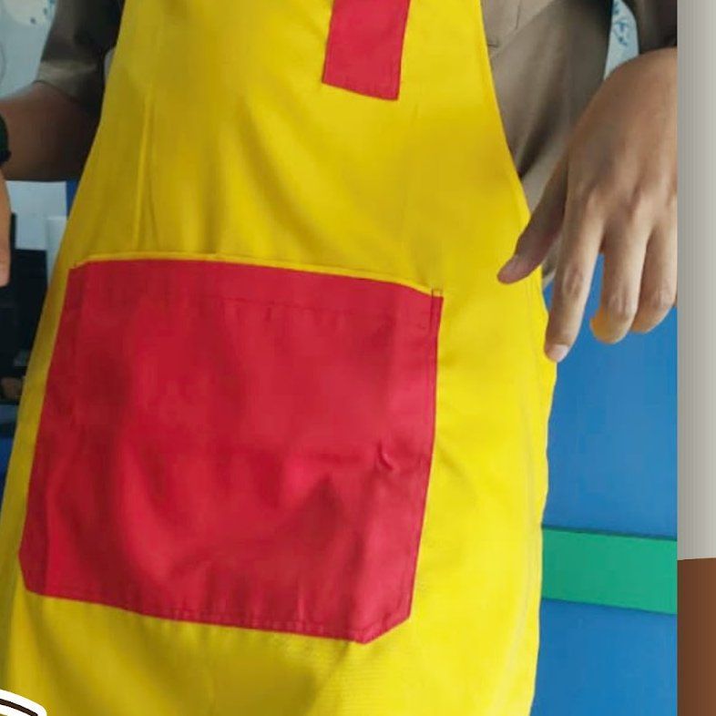 Apron kuning dengan saku merah dipakai